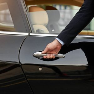 Businessman, hands and chauffeur by car door for travel accommodation, designated driver or commute. Hand of male person on vehicle handle in professional transport service, business class or pick up.